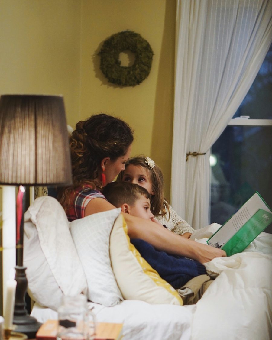 Mother reading to her children by lamplight — the personal connection that matters most