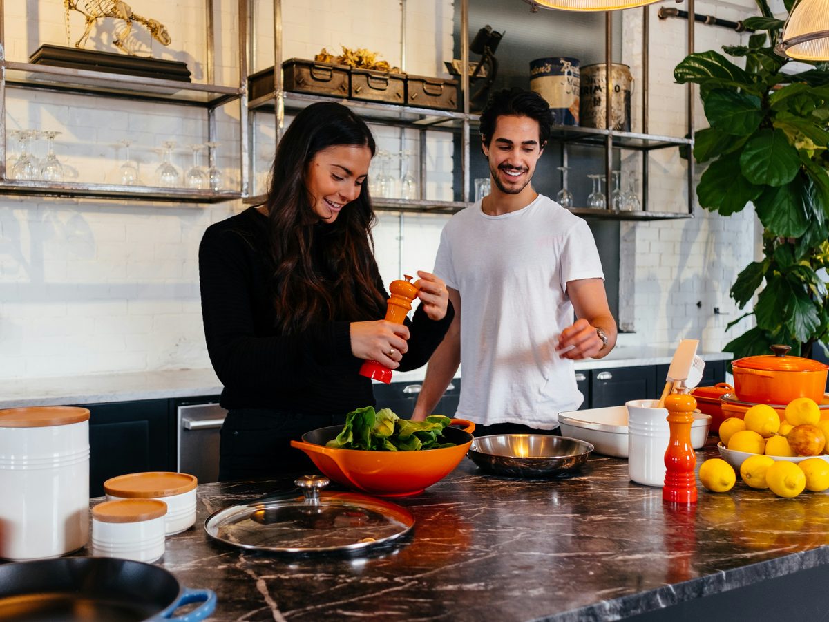 Young couple cooking together at home — building a life together